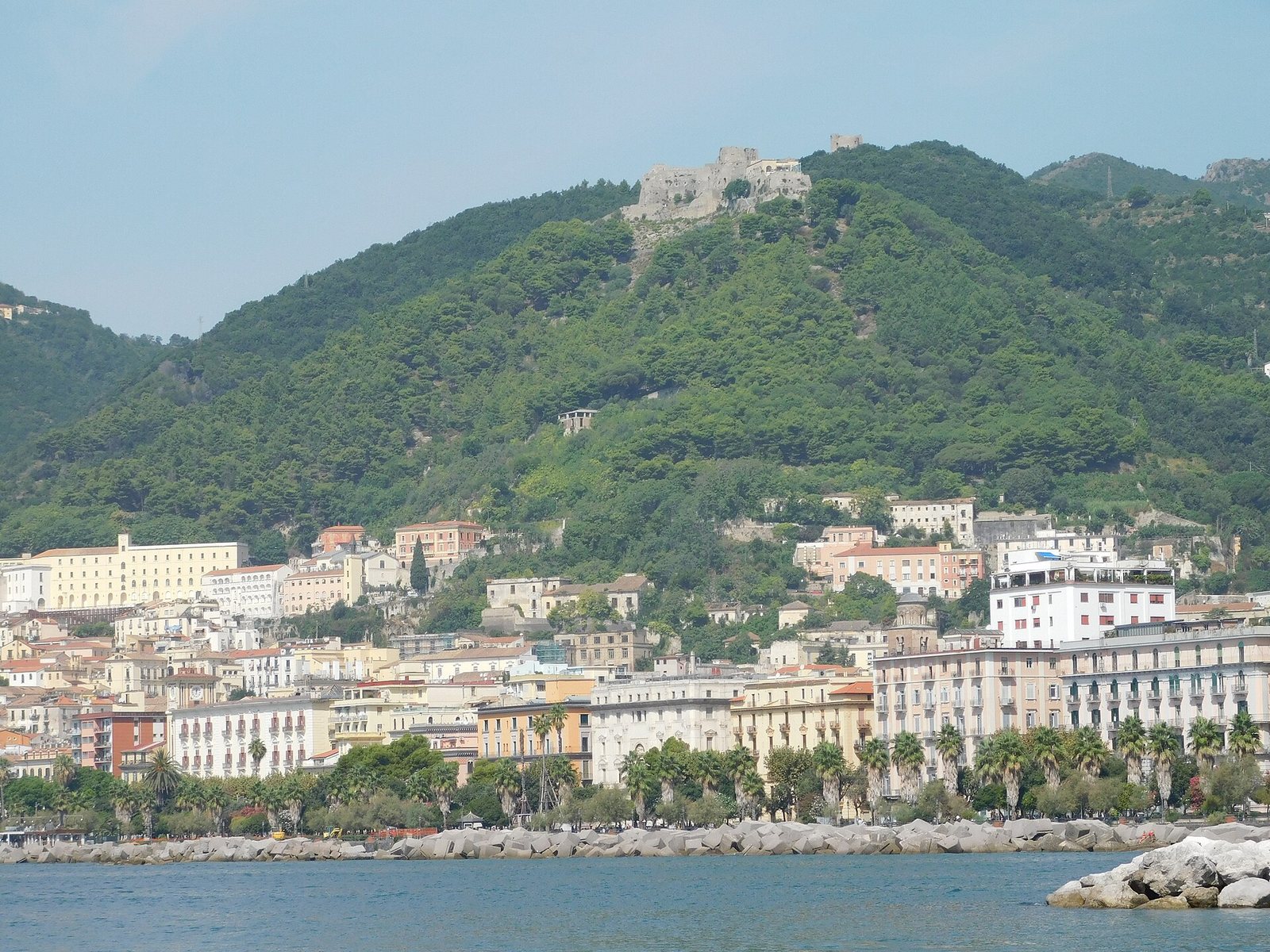 Lungomare di Salerno con palazzi, palme e il Castello di Arechi sulla collina alle spalle